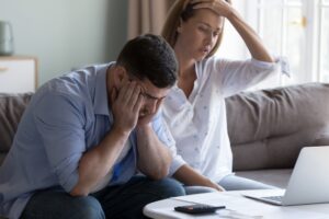 Stressed spouses manage family finances, analyze expenses, check savings and budget